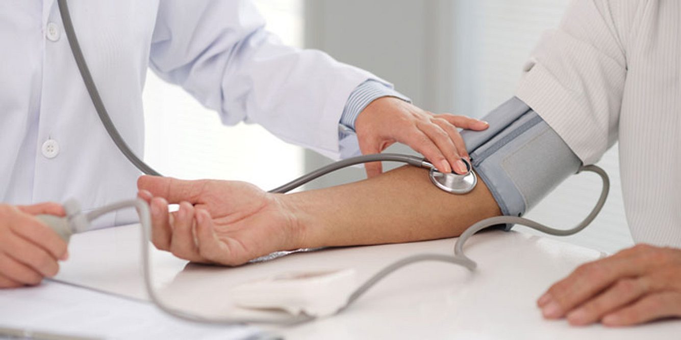 Arzt misst den Blutdruck eines Patienten