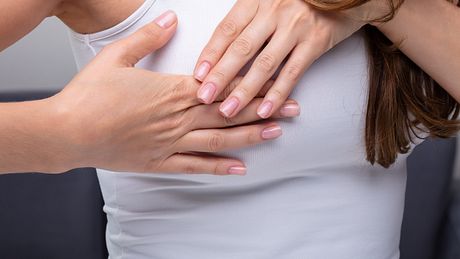 Frau fasst sich an die schmerzende Brust - Foto: istock/andreypopov