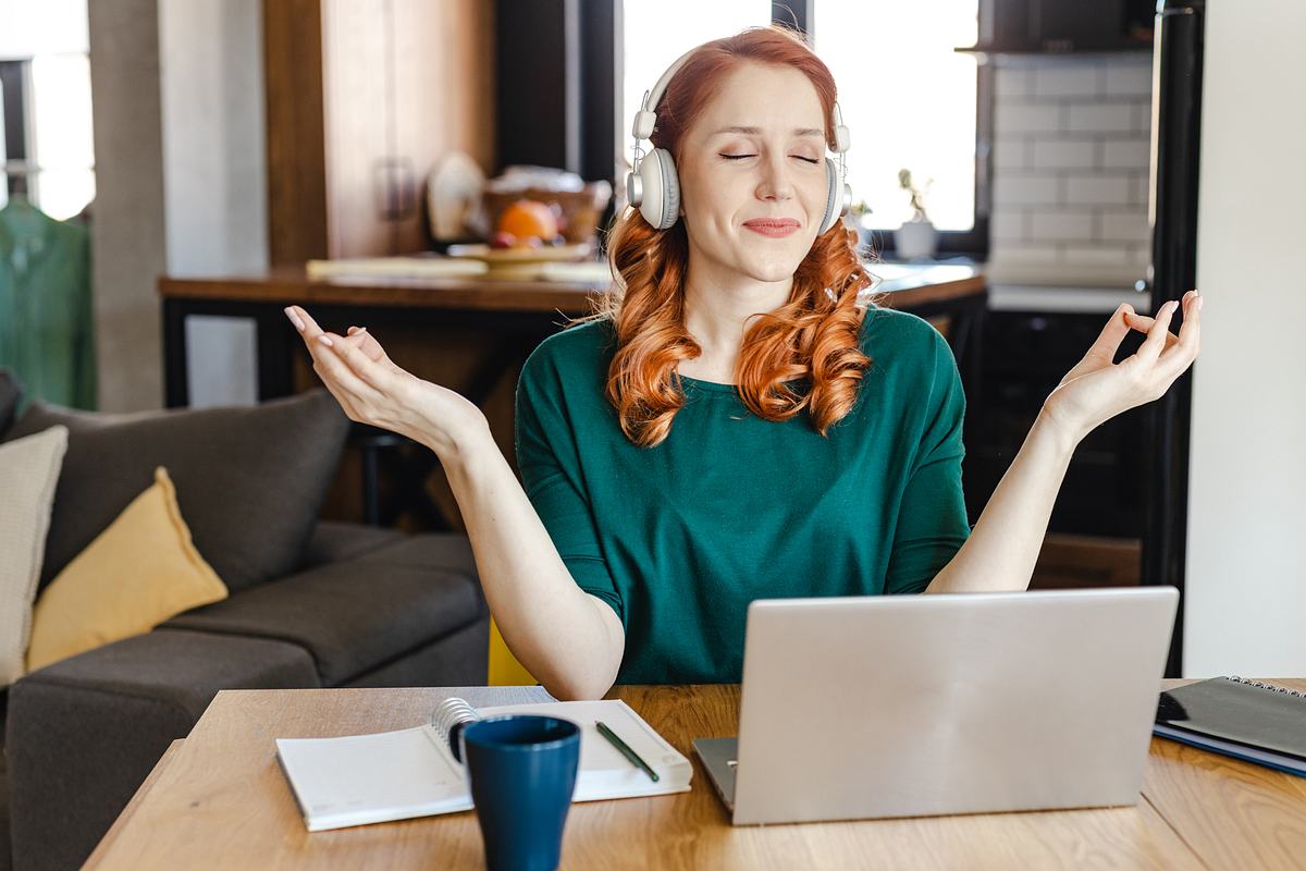 burnout-pravention Frau meditiert vorm Laptop