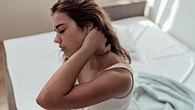 Eine Frau mit schmerzendem Nacken. - Foto: iStock / PixelsEffect