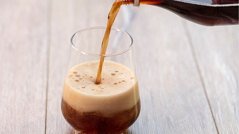Cola wird in ein Glas gegossen. - Foto: iStock/JustHappy