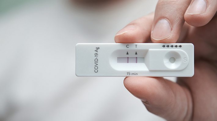 Person hält positiven Coronatest in der Hand - Foto: Istock/Ladanifer