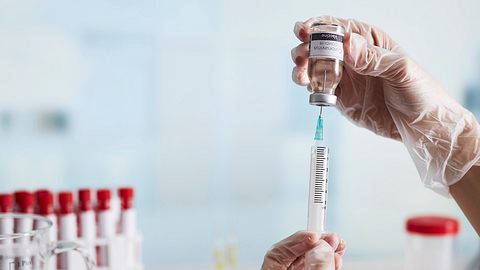 Arzt bereitet die Spritze mit der Kur für die Impfung vor - Foto: iStock / bombuscreative