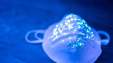 FFP-2-Maske mit leuchtenden Punkten in blauem Licht - Foto: istock / Vladimir Vladimirov