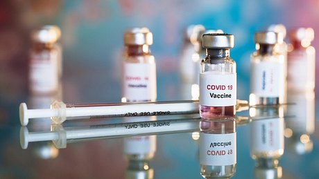 Mehrere Corona-Impfstoffdosen und eine Spritze - Foto: istock_kiattisakch