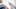 Mann mit Maske krempelt sich den Ärmel hoch, im Vordergrund wird eine Spritze mit Impfstoff aufgezogen - Foto: iStock / South_agency