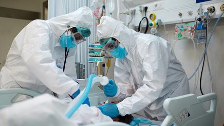 Ärzte in Schutzkleidung intubieren einen Corona-Patienten - Foto: iStock/Tempura