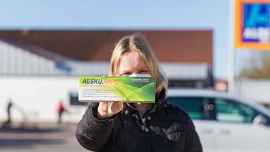 Frau hält Corona-Schnelltest von Aldi in der Hand - Foto: IMAGO / MedienServiceMüller