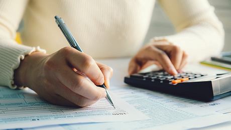 Hände einer Frau beim Ausfüllen von Steuerformularen mit Stift und Taschenrechner - Foto: iStock/pcess609 Hände einer Frau beim Ausfüllen von Steuerformularen mit Stift und Taschenrechner - Foto: iStock/pcess609