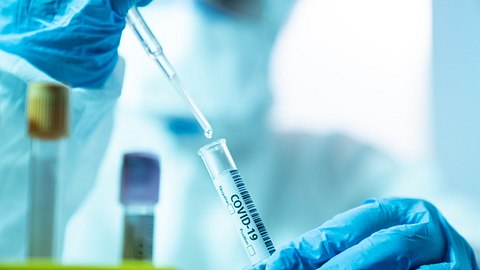 Ein Labormitarbeiter untersucht eine Corona-Probe - Foto: istock_selimaksan