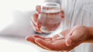 Frau hält Cortison Tabletten in der Hand - Foto: iStock/ljubaphoto