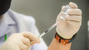 Person zieht Impfstoff-Ampulle auf - Foto: IMAGO/ZUMA Wire