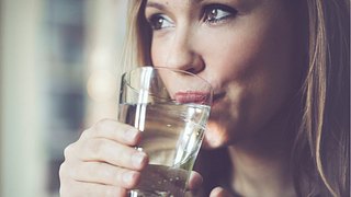 Frau trinkt ein Glas Wasser - Foto: iStock/Eva-Katalin