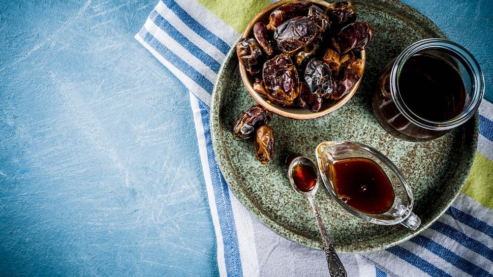 Dattelsirup und Datteln liegen auf einem Tablet - Foto: iStock/Rimma_Bondarenko