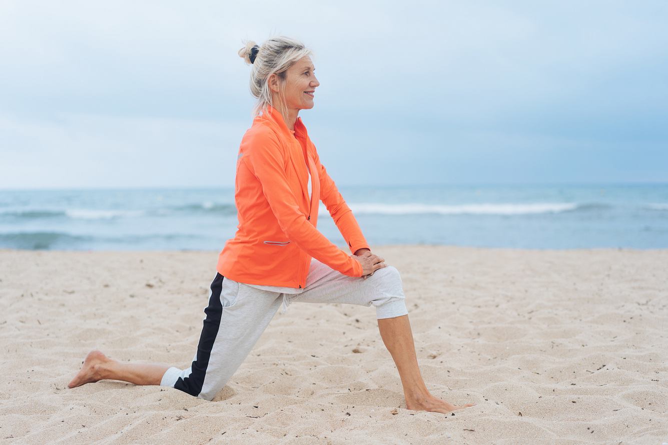 Eine Frau dehnt sich am Strand Eine Frau dehnt sich am Strand