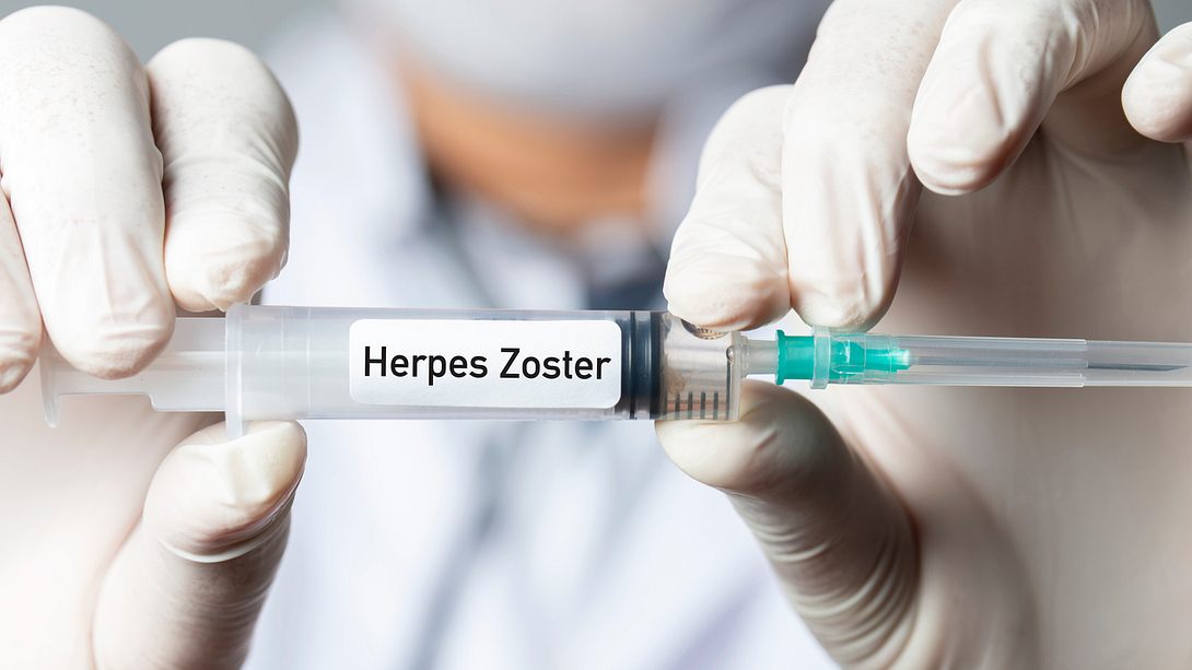 Hände in Schutzhandschuhen halten Spritze mit „Herpes Zoster - Foto: istock/kemalbas