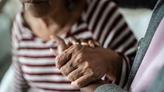 Pflegerin hält die Hand einer älteren Frau - Foto: iStock/FG Trade