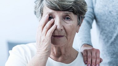 Eine alte vergessliche Frau greift sich an den Kopf - Foto: iStock/KatarzynaBialasiewicz