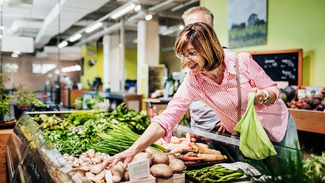 Eine ältere Frau kauft Gemüse ein. - Foto: iStock / TommL