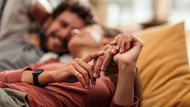 Ein verliebtes Pärchen kuschelt und lacht dabei - Foto: iStock/mihailomilovanovic