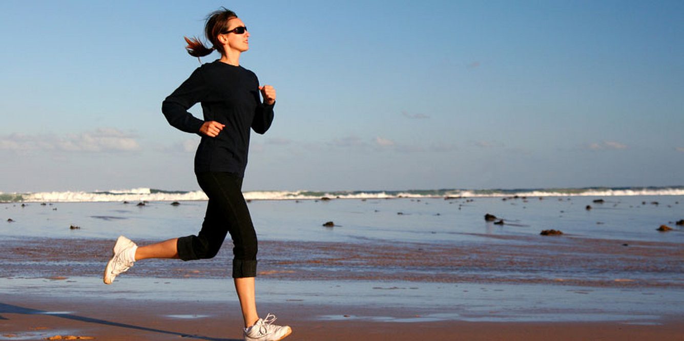 Frau joggt am Strand