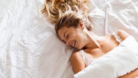 Frau liegt auf dem Bett - Foto: istock/Jasmina007