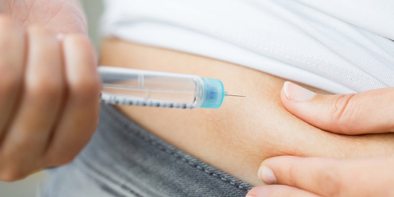 Eine Diabetikerin spritzt sich Insulin in den Bauch
