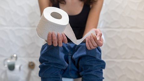 Eine Frau sitzt auf Toilette - Foto: iStock/bymuratdeniz
