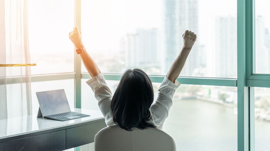 Frau am Schreibtisch streckt sich entspannt - Foto: iStock/Chinnapong