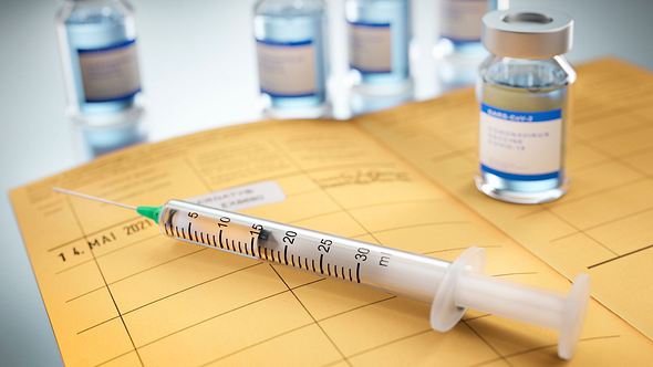 Impfspritze mit Impfausweis und Impfstoff - Foto: iStock/peterschreiber.media
