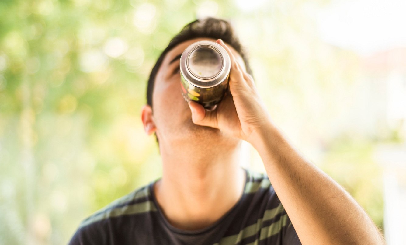 Junge in der Pubertät trinkt Bier aus der Dose