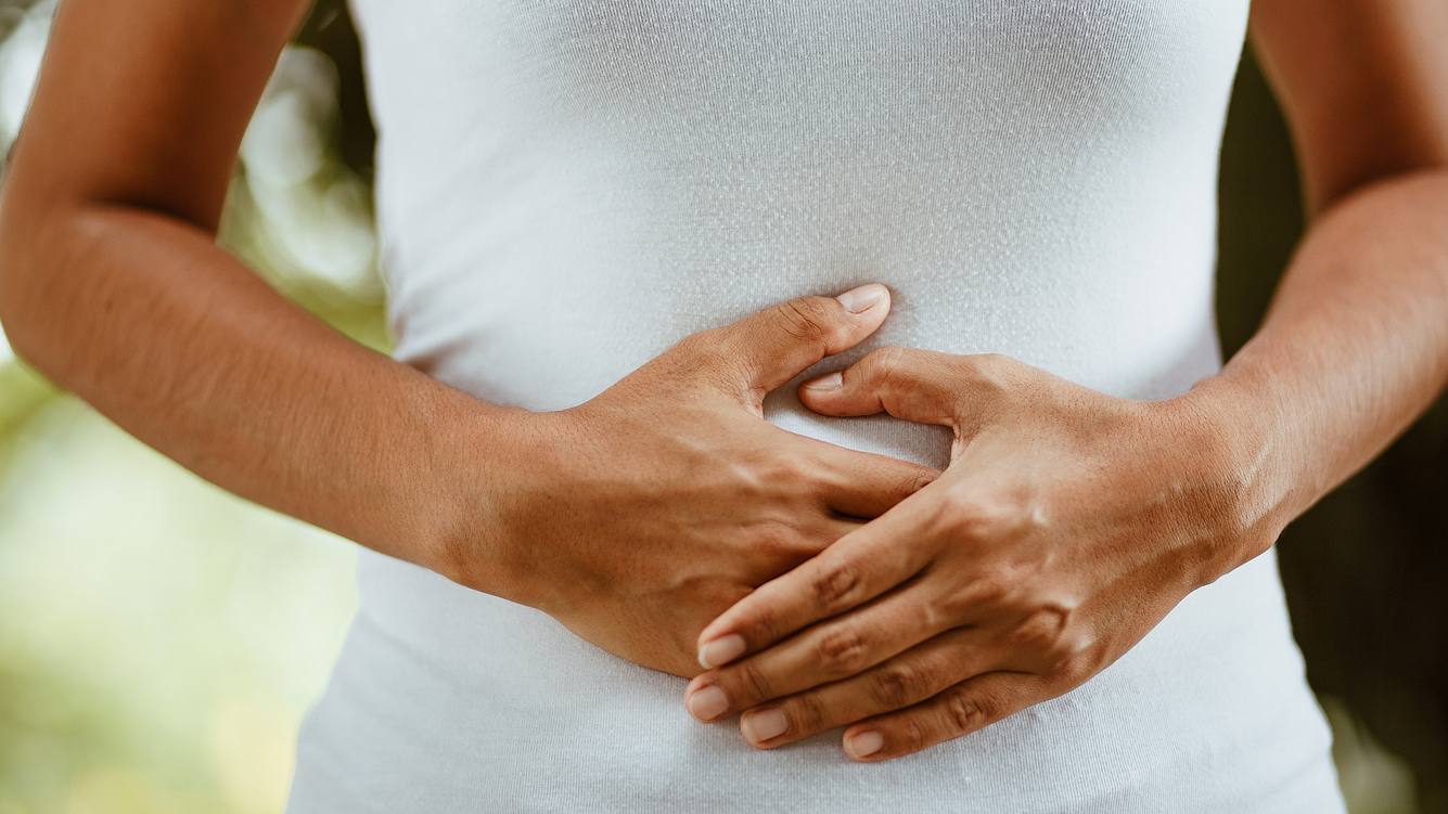 einlauf-selber-machen Bauch einer Frau, sie legt die Hände auf den Bauch