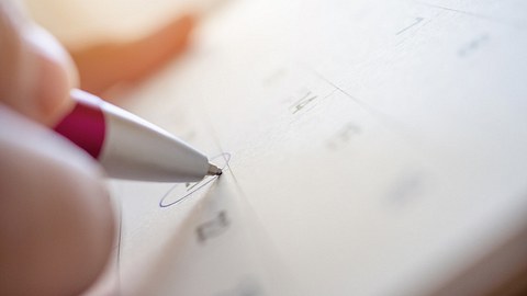Frau trägt Datum in Eisprungkalender ein - Foto: iStock/Kwangmoozaa