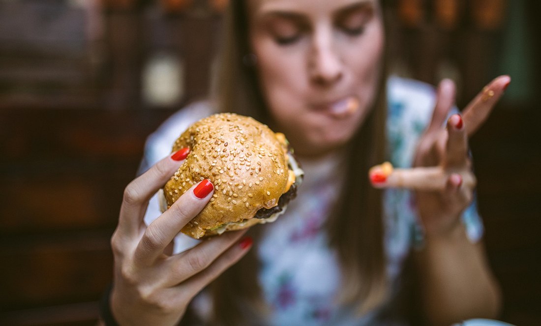 Eine Frau isst einen Burger