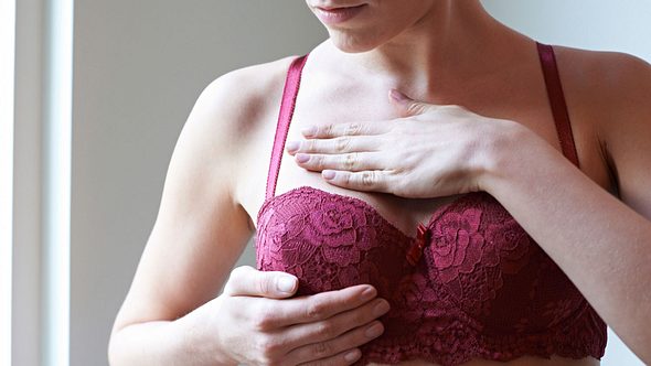 Frau im BH tastet ihre Brust ab - Foto: iStock/MachineHeadz