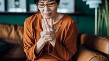 Eine Frau massiert ihre Hand. - Foto: iStock / AsiaVision