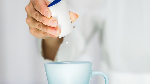 Frau macht Süßstoff in Tasse - Foto:  iStock/bluecinema