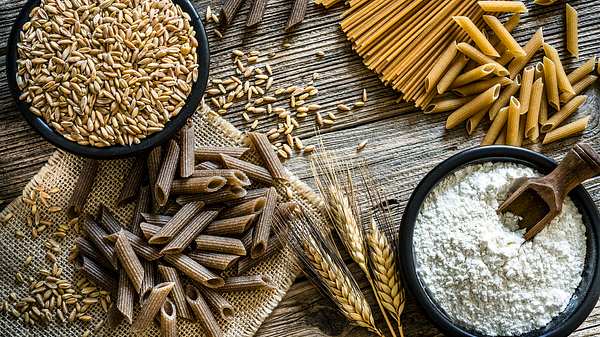 Vollkornnudeln, Dinkel und Mehl auf einem rustikalen Holztisch - Foto: iStock-1178319150 fcafotodigital