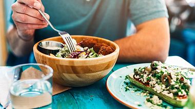 Mann isst Salat aus Holzschüssel - Foto: iStock/VioletaStoimenova