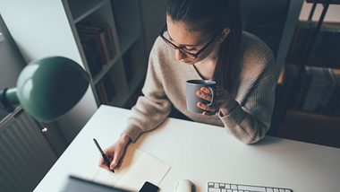 Eine Frau sitzt konzentriert am Schreibtisch - Foto: iStock/fizkes