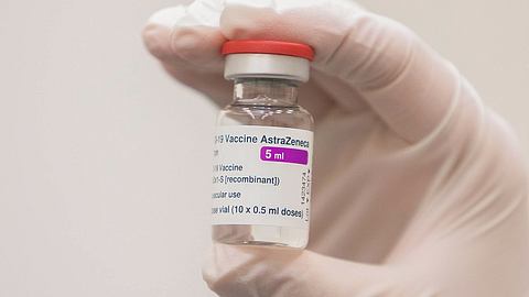 Eine Person hält eine AstraZeneca-Impfdosis in der Hand - Foto: IMAGO_Scanpix