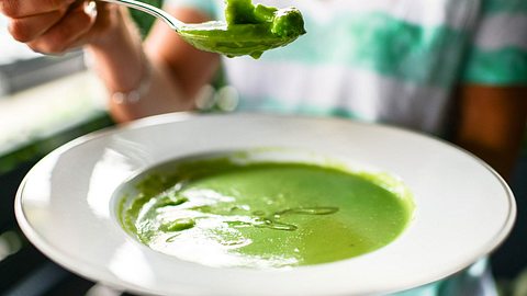 Frau isst grüne Brokkolisuppe - Foto: iStock/anouchka
