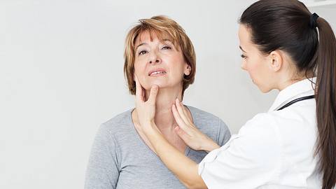 Ärztin tastet Hals einer Patientin ab - Foto: iStock/BakiBG