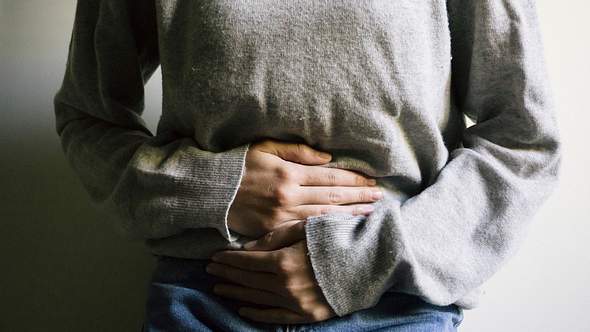 Frau hält sich ihre Hände schützend vor den Bauch - Foto: iStock_Carlo107
