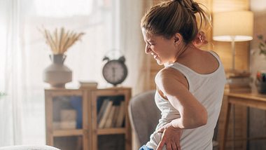 Frau mit Fibromyalgie hat Schmerzen am seitlichen Rücken - Foto: iStock/zeljkosantrac