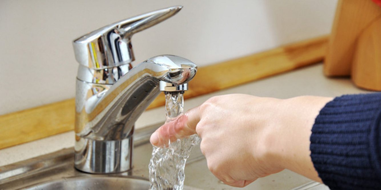 Ein Junge hält seinen Finger unter Wasser