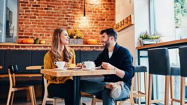 Frau und Mann sitzen am Tisch und reden miteinander - Foto: iStock/BartekSzewczyk