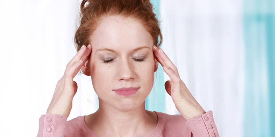 Frau mit starken Kopfschmerzen