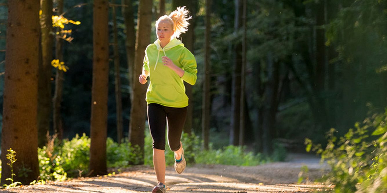 Eine Frau joggt im Wald