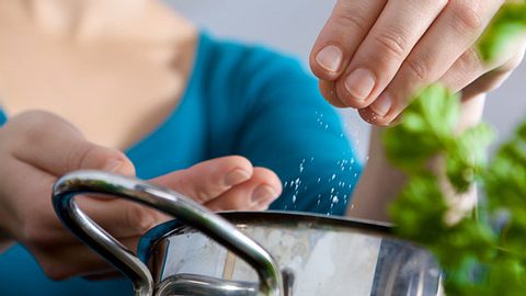 Eine Frau schüttet Salz in einen Topf - Foto: Fotolia